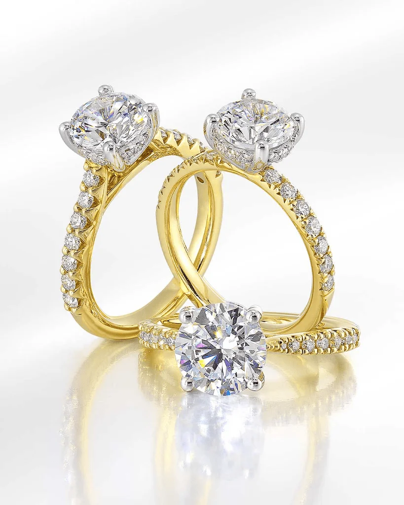 Yellow gold pavé and halo engagement rings with round diamond center stones